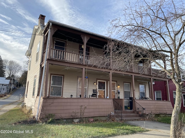 view of front of property featuring a porch and a balcony