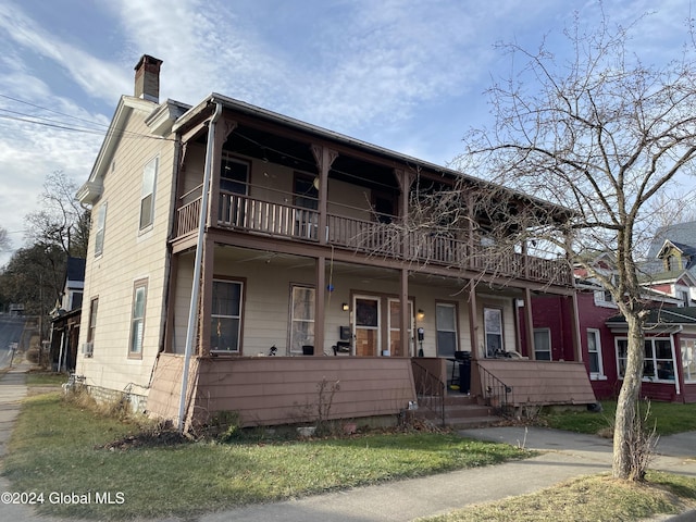 view of front facade with covered porch and a balcony