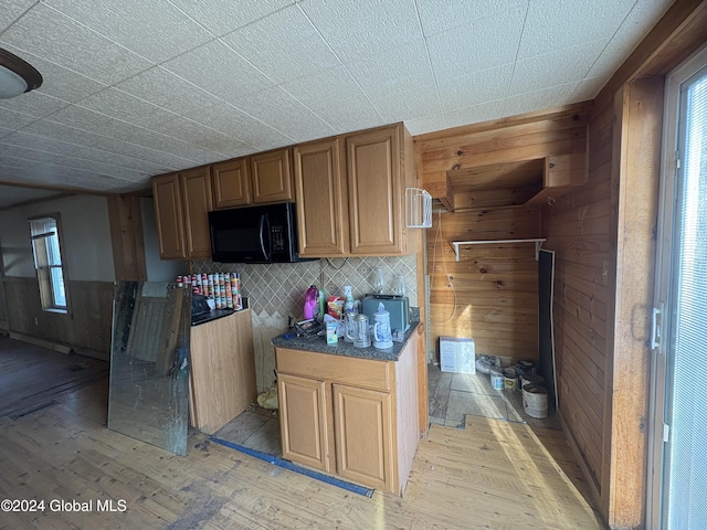 kitchen featuring wood walls, backsplash, and light hardwood / wood-style flooring