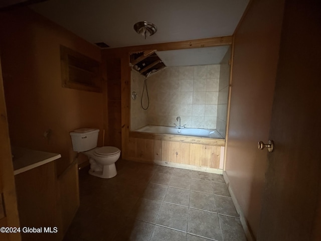 bathroom featuring a washtub, tile patterned flooring, and toilet