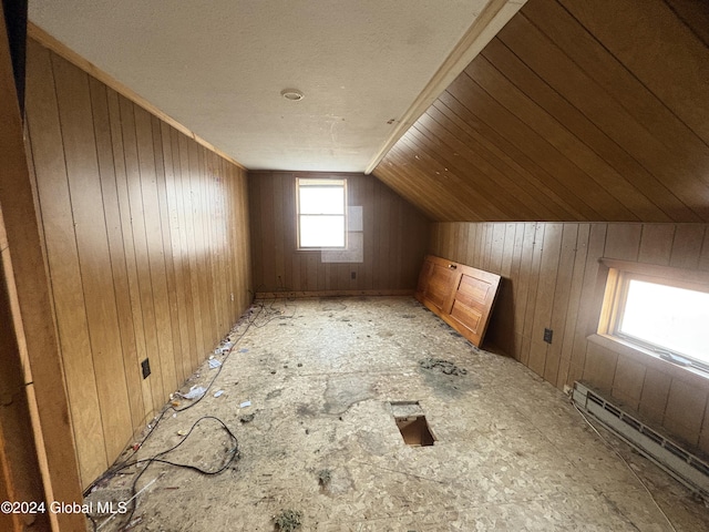 bonus room featuring lofted ceiling, wooden walls, and a baseboard heating unit