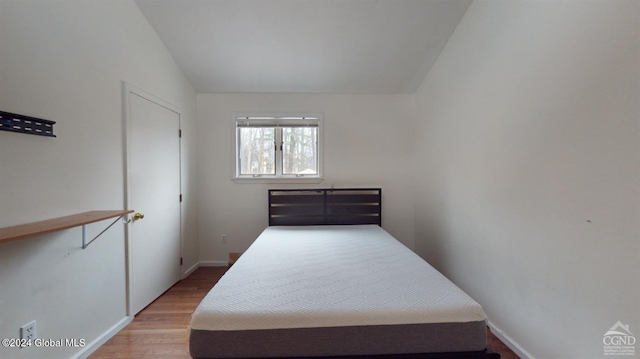 bedroom featuring hardwood / wood-style floors and vaulted ceiling