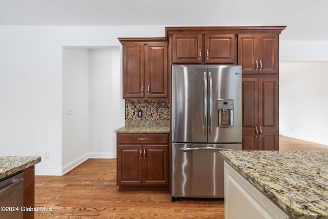 kitchen with light stone countertops, appliances with stainless steel finishes, decorative backsplash, and dark hardwood / wood-style floors