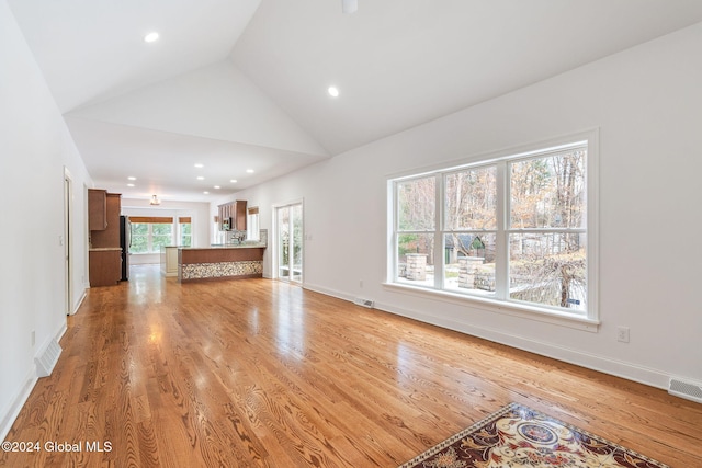 unfurnished living room featuring light hardwood / wood-style floors and high vaulted ceiling