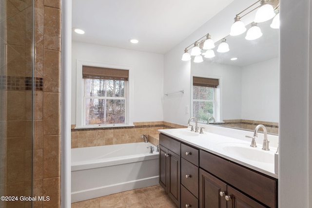 bathroom featuring tile patterned flooring, vanity, and a bath