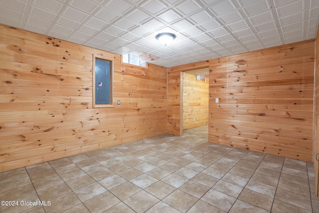 unfurnished room featuring electric panel and wooden walls