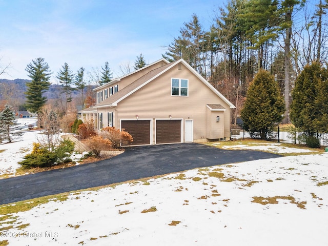 view of snowy exterior featuring a garage