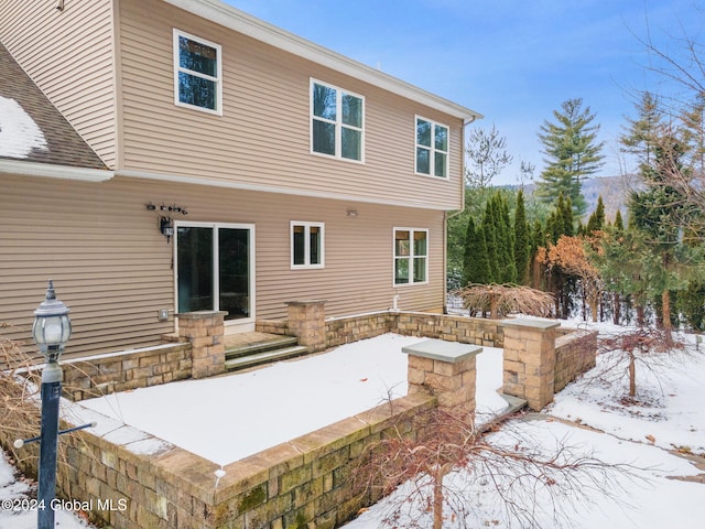 view of snow covered rear of property