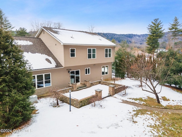 view of snow covered rear of property