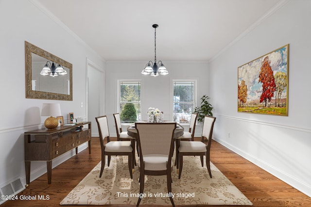 dining room with dark hardwood / wood-style flooring, ornamental molding, and a chandelier