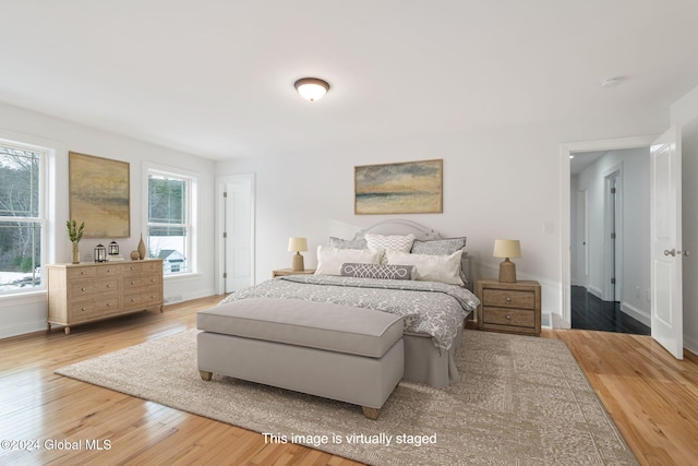 bedroom with multiple windows and hardwood / wood-style floors