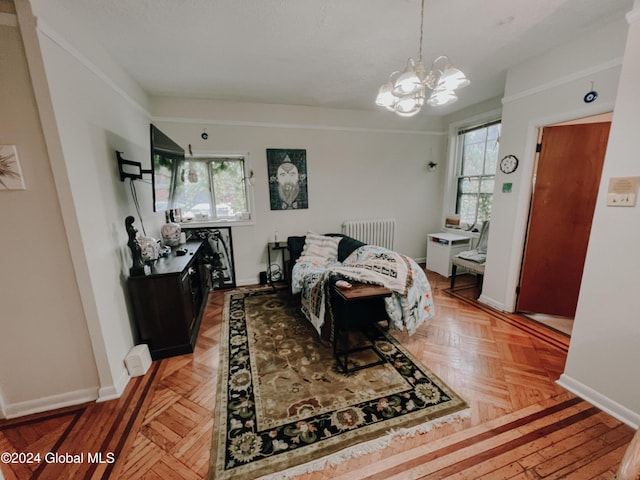 bedroom with crown molding, radiator heating unit, light parquet flooring, and a chandelier