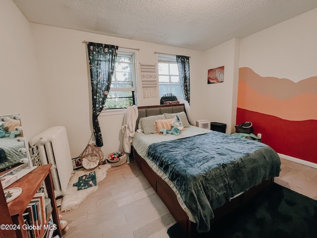 bedroom featuring a textured ceiling and radiator