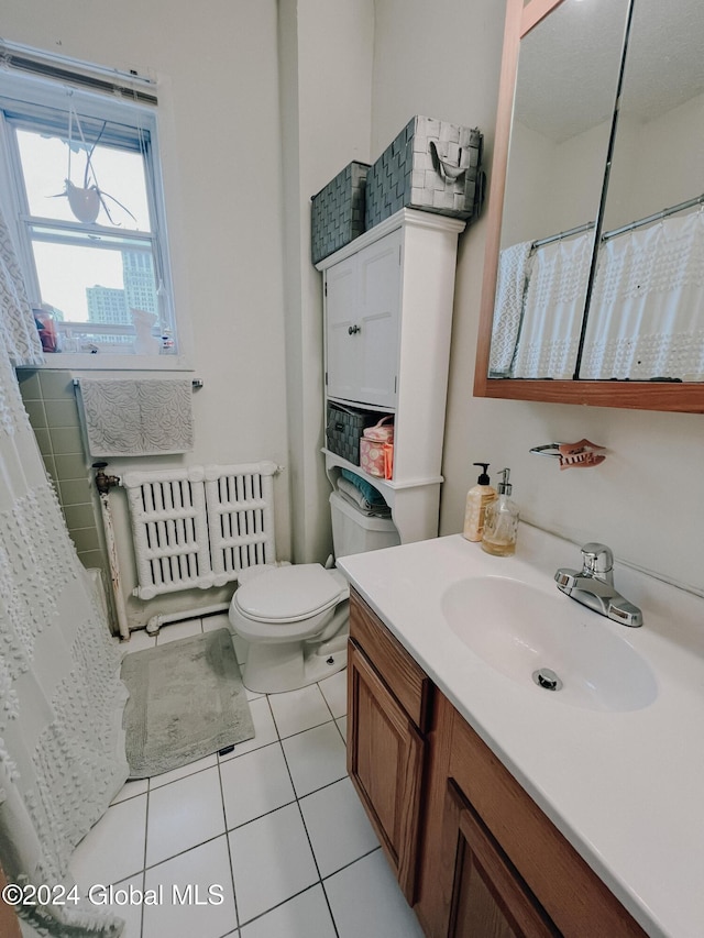 bathroom featuring tile patterned floors, radiator heating unit, vanity, and toilet