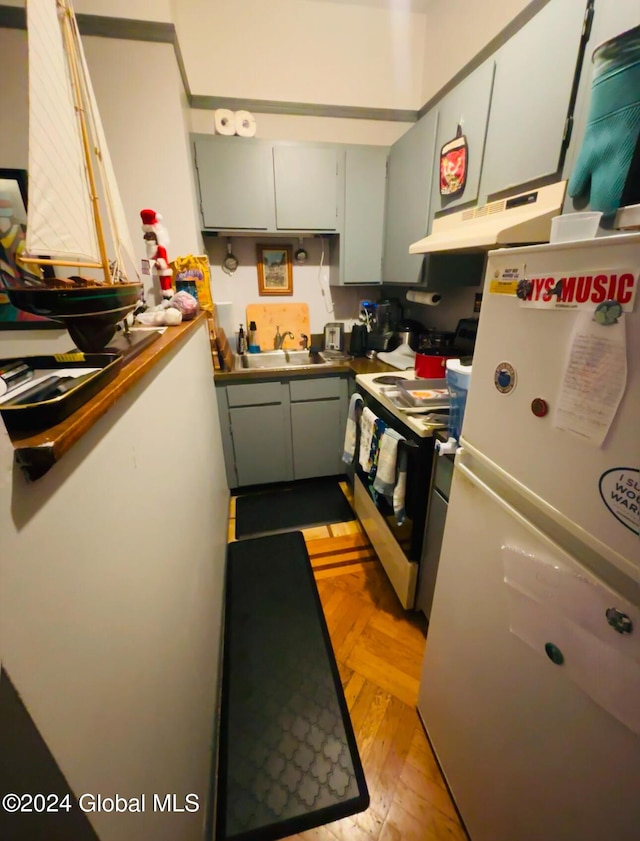 kitchen featuring white appliances, gray cabinets, light parquet flooring, and sink