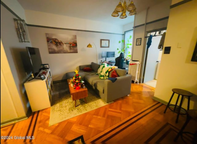 living room featuring light parquet flooring and a notable chandelier