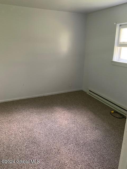 spare room with carpet and a baseboard radiator