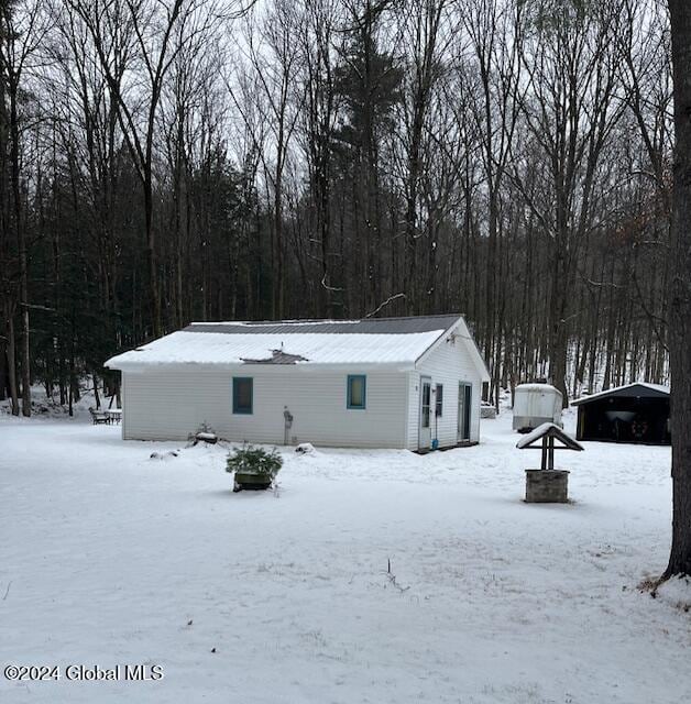 view of snow covered back of property