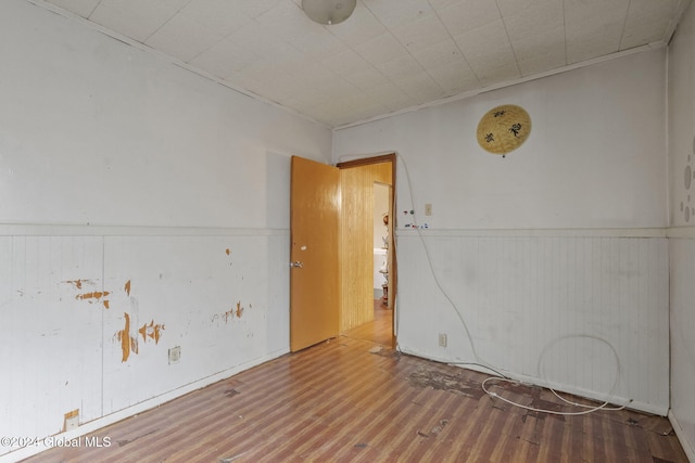 spare room featuring wooden walls and hardwood / wood-style floors