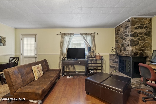 living room with a fireplace, wood-type flooring, and crown molding