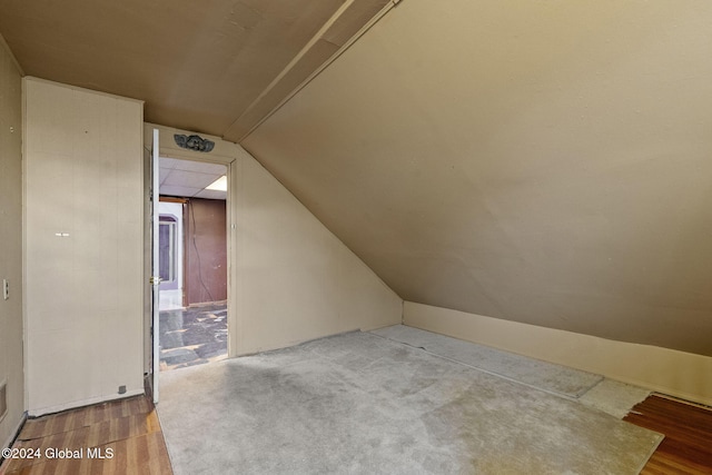 bonus room with hardwood / wood-style floors and vaulted ceiling