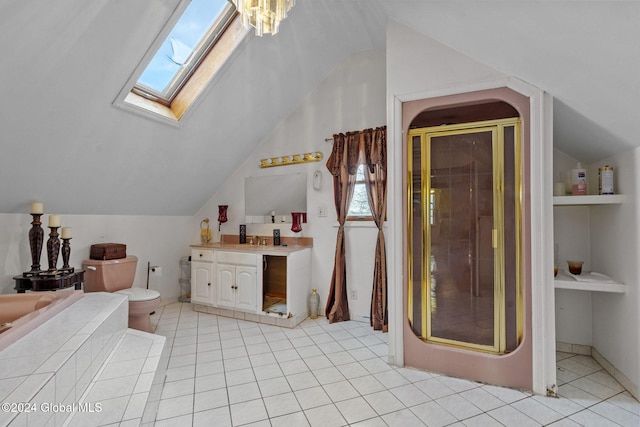 full bathroom featuring tile patterned flooring, separate shower and tub, toilet, vaulted ceiling with skylight, and vanity