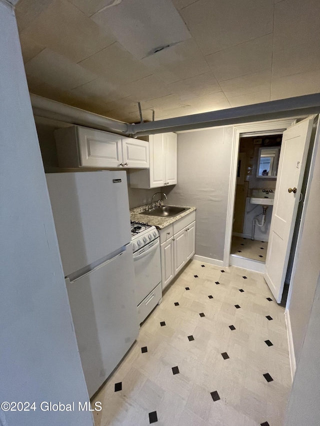 kitchen with sink, white cabinets, and white appliances