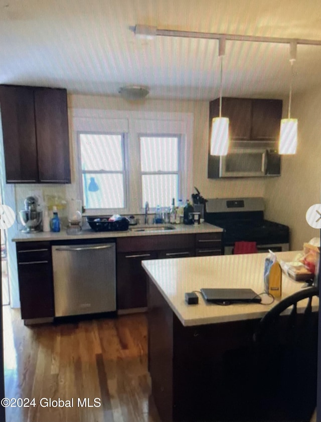 kitchen with stainless steel dishwasher, dark brown cabinets, dark wood-type flooring, sink, and range