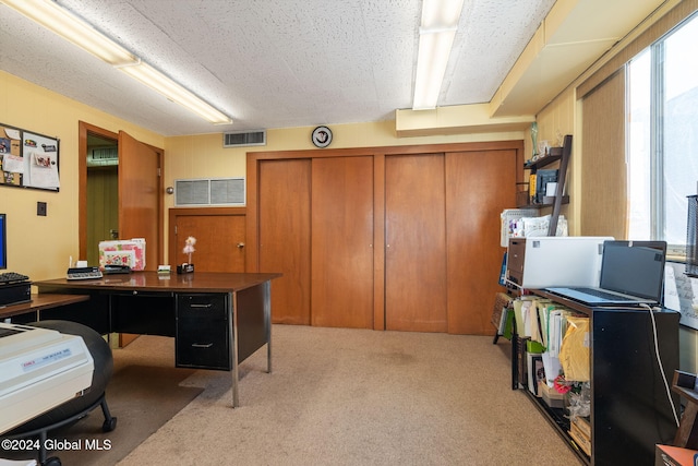 home office featuring a textured ceiling and light carpet