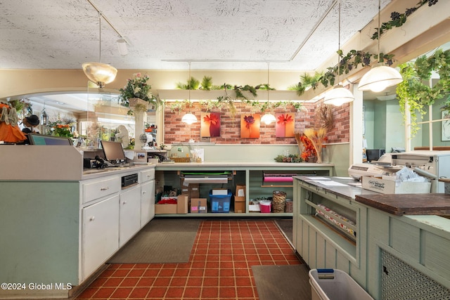 kitchen with white cabinets, pendant lighting, a textured ceiling, and green cabinetry