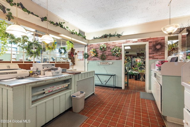 kitchen featuring green cabinets, hanging light fixtures, and a textured ceiling