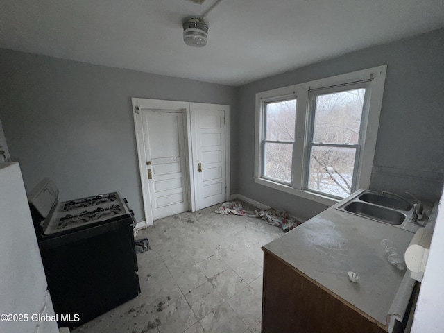 interior space featuring light floors, a sink, and baseboards