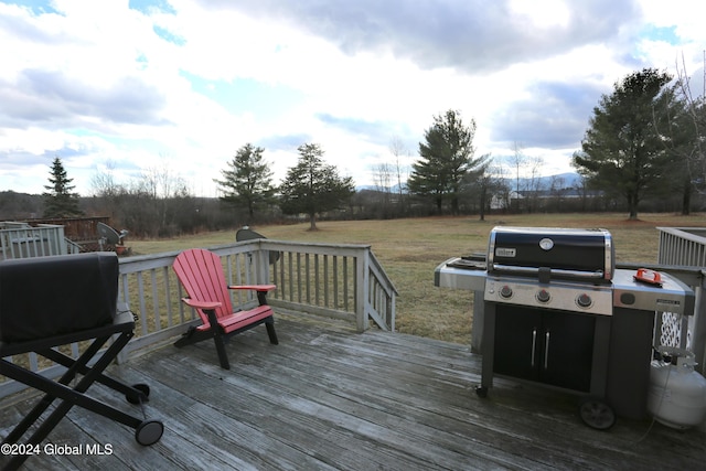 wooden terrace with a yard and grilling area