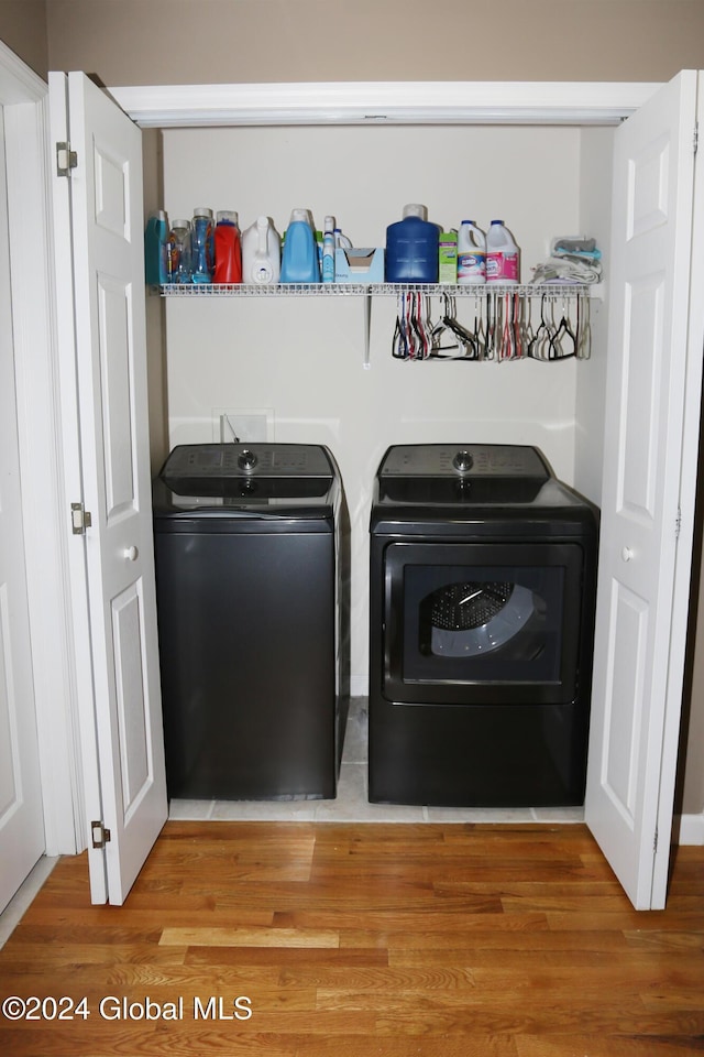 clothes washing area with wood-type flooring and washing machine and clothes dryer