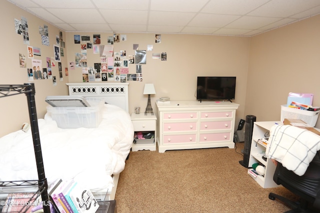 carpeted bedroom featuring a drop ceiling