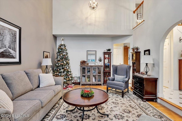 living room with a towering ceiling and light hardwood / wood-style floors