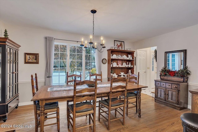 dining space featuring light hardwood / wood-style flooring and a notable chandelier