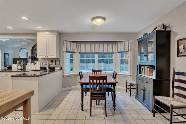 dining space featuring ceiling fan, light tile patterned flooring, and sink