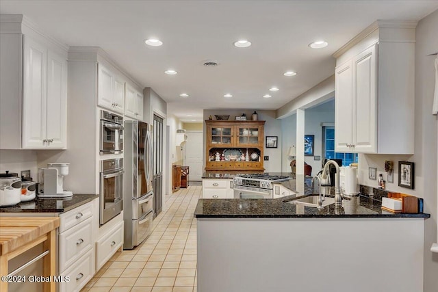 kitchen with white cabinetry, kitchen peninsula, and appliances with stainless steel finishes