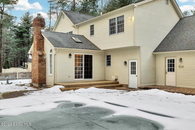 view of snow covered back of property