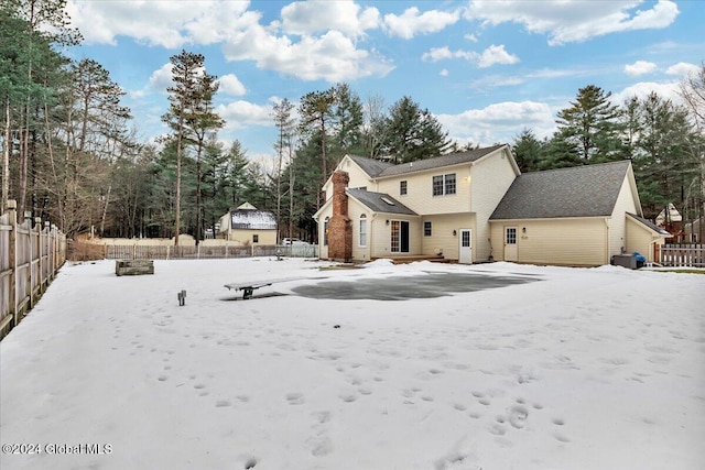 view of snow covered rear of property