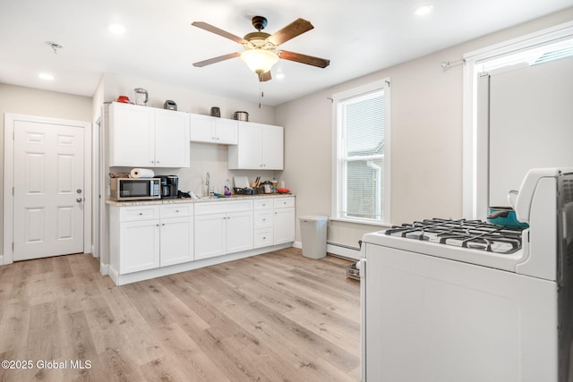 kitchen featuring white cabinetry, white gas range, light hardwood / wood-style flooring, and a baseboard heating unit