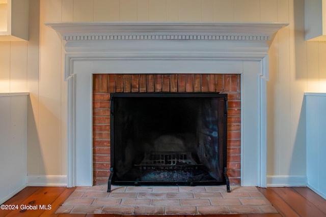 interior details with hardwood / wood-style floors and a brick fireplace