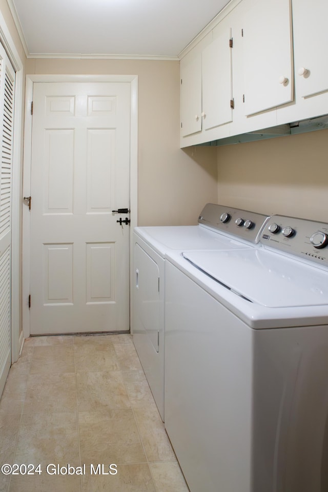 clothes washing area with cabinets, washing machine and dryer, and ornamental molding