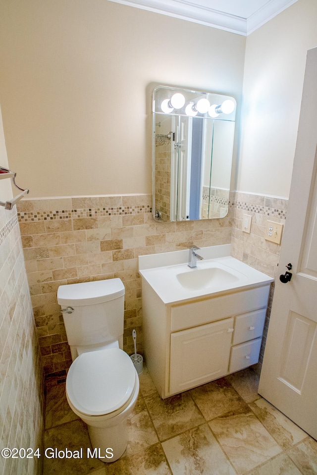 bathroom with vanity, toilet, tile walls, and ornamental molding