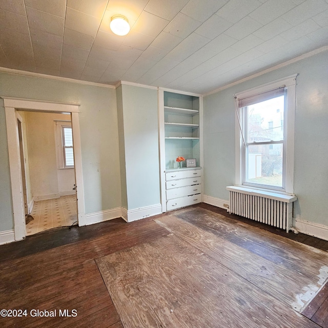 unfurnished bedroom featuring dark hardwood / wood-style flooring, radiator, and crown molding