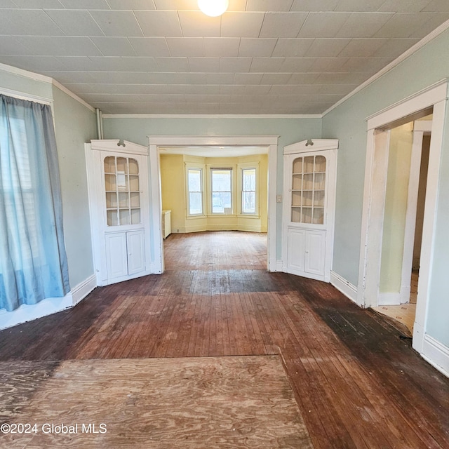 empty room with dark hardwood / wood-style flooring and ornamental molding