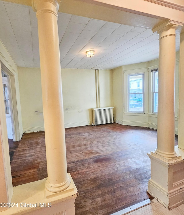 basement featuring radiator heating unit and hardwood / wood-style flooring