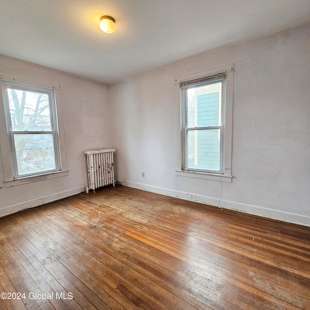 spare room with hardwood / wood-style floors and radiator