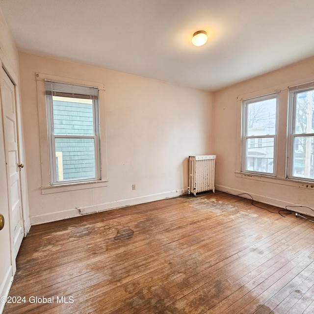 empty room featuring hardwood / wood-style flooring and radiator